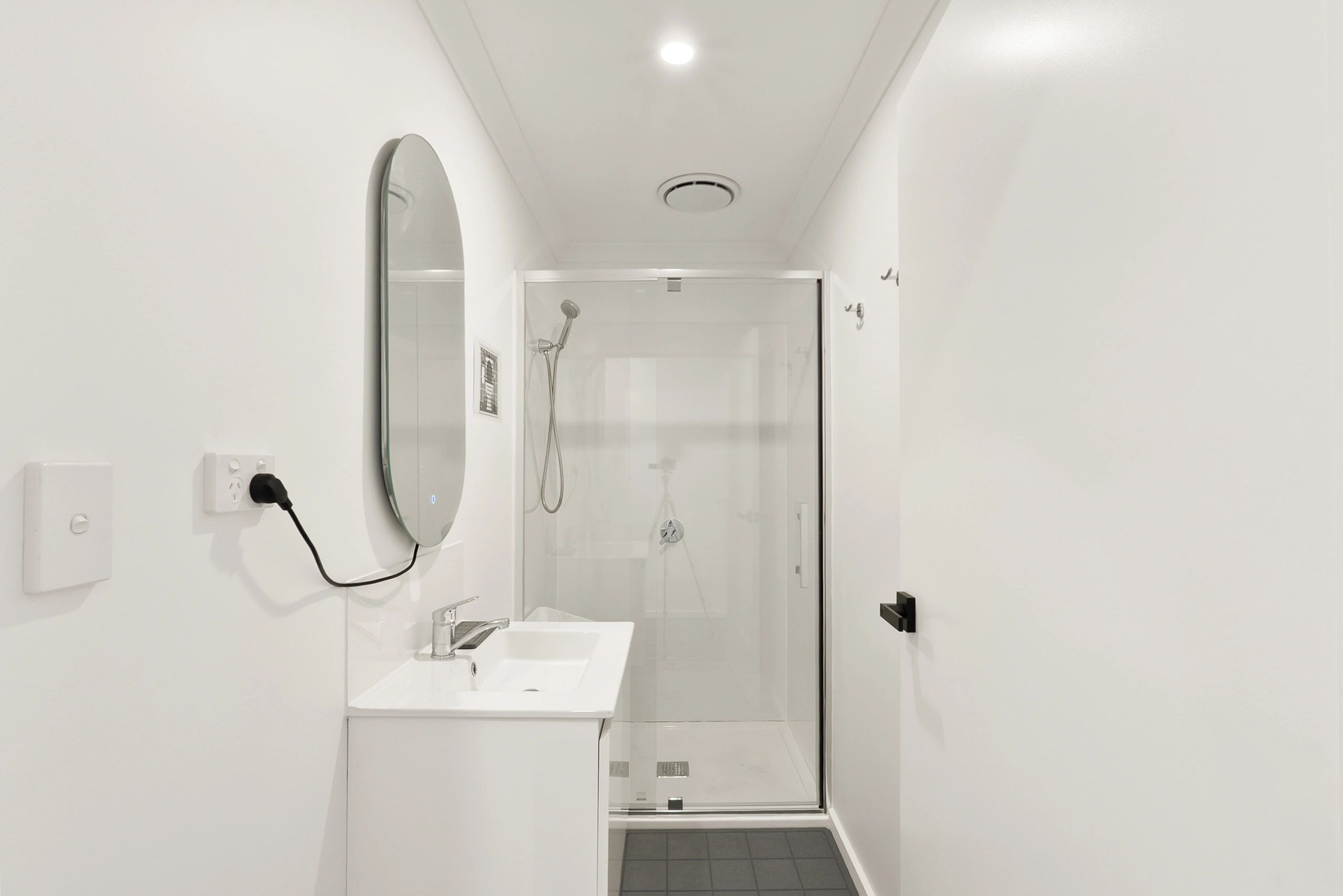 Modern bathroom with shower and oval mirror